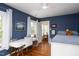Inviting bedroom with blue walls, hardwood floors, a desk area, and a bed with patterned bedding at 1603 Hermitage Ct, Durham, NC 27707