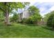 Beautiful gray home with a green lawn and trees. A red door adds a splash of color at 1603 Hermitage Ct, Durham, NC 27707
