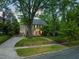 A two-story home with a manicured lawn, mature trees, and inviting curb appeal at dusk at 1603 Hermitage Ct, Durham, NC 27707