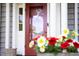Close up on a red door framed by white trim and colorful flowers at 1603 Hermitage Ct, Durham, NC 27707