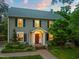 Charming two-story home with a classic red door, black shutters, and beautifully landscaped front yard at 1603 Hermitage Ct, Durham, NC 27707