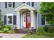 Close-up of the front porch featuring a bright red door, white pillars, and decorative flower pots, creating a welcoming entrance at 1603 Hermitage Ct, Durham, NC 27707