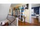 Hallway with a staircase, open doorway to blue office, globe and a bookcase filled with books and globes at 1603 Hermitage Ct, Durham, NC 27707