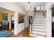 Spacious hallway featuring staircase, chandelier and colorful art at 1603 Hermitage Ct, Durham, NC 27707