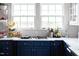 Kitchen features white marble countertops and sleek, dark blue cabinetry at 1603 Hermitage Ct, Durham, NC 27707