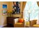 Comfortable sitting area with mustard colored chairs, a chest of drawers, and a view to the backyard at 1603 Hermitage Ct, Durham, NC 27707