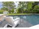 Swimming pool with jacuzzi tub and a white plastic deck chair on the edge at 1603 Hermitage Ct, Durham, NC 27707