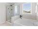 Luxurious bathroom featuring a separate shower and soaking tub near a window at 176 Belleforte Park Cir, Garner, NC 27529