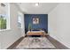 Bright home office featuring hardwood floors, a stylish desk, and a cozy blue accent chair at 176 Belleforte Park Cir, Garner, NC 27529