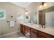 Bathroom with double sinks, wood cabinets, neutral walls, tile floors, and windows allowing for natural light at 19002 Stone Brk, Chapel Hill, NC 27517