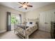 Cozy bedroom features a metal bed frame, neutral walls, plush carpet, and natural light from a large window at 19002 Stone Brk, Chapel Hill, NC 27517