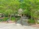 Charming home facade framed by lush trees and landscaping, complemented by a welcoming driveway at 19002 Stone Brk, Chapel Hill, NC 27517