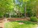 Landscaped front yard showcasing mature trees and manicured lawn, partially obscuring the home's facade at 19002 Stone Brk, Chapel Hill, NC 27517