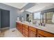 Main bathroom boasts double vanity with granite countertop, a framed mirror, and step-in shower at 19002 Stone Brk, Chapel Hill, NC 27517