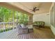 Relaxing screened porch with ceiling fan, wooden floors, comfortable wicker seating, and views of a green forest at 19002 Stone Brk, Chapel Hill, NC 27517