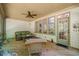 Screened-in porch provides an outdoor lounge area with a wicker sofa, wooden floors, and ceiling fan at 19002 Stone Brk, Chapel Hill, NC 27517