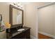 Powder room with a black vanity, granite countertop, ornate mirror, decorative lighting, and hardwood flooring at 19002 Stone Brk, Chapel Hill, NC 27517