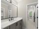 Bathroom with modern vanity, stone countertop, black faucet and large mirror at 1904 French Dr, Raleigh, NC 27612