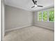 Bedroom featuring neutral paint and carpet, ceiling fan and windows with green views at 1904 French Dr, Raleigh, NC 27612