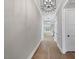 Long hallway with hardwood floors, white trim, and stylish light fixtures at 1904 French Dr, Raleigh, NC 27612