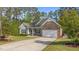 Charming single-story home featuring a stone facade, manicured lawn, and an attached two-car garage at 2005 Delphi Way, Wake Forest, NC 27587