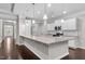 Modern kitchen featuring granite countertops, stainless steel appliances, white cabinetry, and hardwood floors at 2005 Delphi Way, Wake Forest, NC 27587