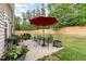 Fenced backyard with patio, chairs, table, umbrella and room for entertainment at 205 Braxcarr St, Holly Springs, NC 27540
