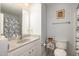 Bright bathroom with a vanity, toilet, and shower at 205 Braxcarr St, Holly Springs, NC 27540
