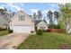 Inviting home featuring a well-maintained lawn, and an attached two-car garage at 205 Braxcarr St, Holly Springs, NC 27540