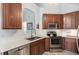 Modern kitchen with stainless steel appliances, wood cabinets, and white countertops at 205 Braxcarr St, Holly Springs, NC 27540
