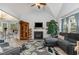 A cozy living room with fireplace, TV, an accent rug, and an archway leading to the dining area at 205 Braxcarr St, Holly Springs, NC 27540
