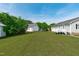 Spacious backyard with lush green grass and mature trees surrounding two homes at 205 Twin Oaks Dr, Angier, NC 27501