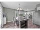 Dining area leading to kitchen featuring a wooden table, hardwood floors and access to the backyard at 205 Twin Oaks Dr, Angier, NC 27501