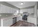Traditional kitchen with laminate countertops, white cabinets, stainless steel appliances and hardwood floors at 205 Twin Oaks Dr, Angier, NC 27501