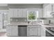 Traditional kitchen featuring white cabinets, laminate countertops, stainless steel appliances and hardwood floors at 205 Twin Oaks Dr, Angier, NC 27501