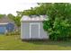 A storage shed surrounded by lush greenery in a backyard setting at 205 Twin Oaks Dr, Angier, NC 27501