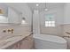 Bathroom with a soaking tub and marble vanity at 207 N Aiken St, Fuquay Varina, NC 27526