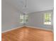 Empty bedroom with neutral walls, hardwood floors, and ample natural light at 207 N Aiken St, Fuquay Varina, NC 27526