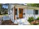 Charming front entrance featuring a wooden door, white brick steps, and beautiful landscaping at 207 N Aiken St, Fuquay Varina, NC 27526