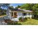Inviting white brick home with a charming front entrance and a lush green lawn at 207 N Aiken St, Fuquay Varina, NC 27526