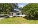 Charming white brick home with a lush green lawn and mature trees at 207 N Aiken St, Fuquay Varina, NC 27526