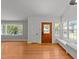 Bright living room with wood floors, a wood door, and a cozy window seat at 207 N Aiken St, Fuquay Varina, NC 27526