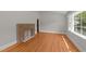 Cozy living room features a fireplace, wood floors, and sun-filled window at 207 N Aiken St, Fuquay Varina, NC 27526