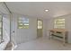 Light filled sunroom with white walls, bead board and two double hung windows, with door, and a small table at 207 N Aiken St, Fuquay Varina, NC 27526