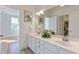 Bathroom featuring double sinks, white cabinets, and stylish decorative artwork at 208 Vervain Way, Holly Springs, NC 27540