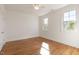 Bright bedroom featuring hardwood floors, natural light, and two windows at 208 Vervain Way, Holly Springs, NC 27540