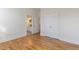 View into bedroom featuring hardwood floors, closet, and view into the bathroom at 208 Vervain Way, Holly Springs, NC 27540
