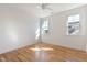 Bright bedroom showcasing natural light, hardwood floors, and two windows at 208 Vervain Way, Holly Springs, NC 27540