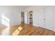 Bright bedroom featuring hardwood floors, two closets, and access to a private bathroom at 208 Vervain Way, Holly Springs, NC 27540