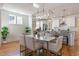 Elegant dining area features a modern chandelier, hardwood floors, and views of the kitchen at 208 Vervain Way, Holly Springs, NC 27540